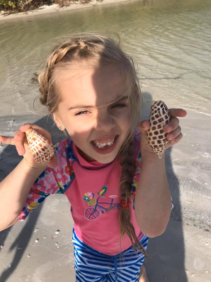 Kid Holding Junonia and Alphabet Cone Shells